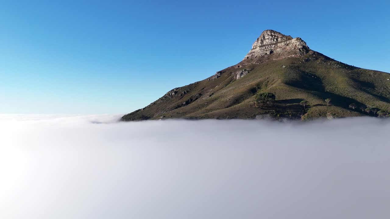 Aerial drone footage of Lion’s Head mountain in Cape Town, South Africa, surrounded by mist and clouds