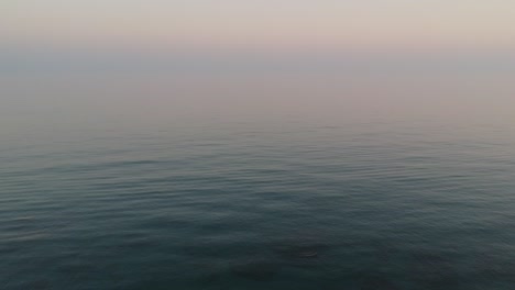 Aerial-view-with-drone-over-a-southern-Spanish-beach-in-Marbella,-Andalusia,-Spain,-calm-waves-on-crystal-clear-water