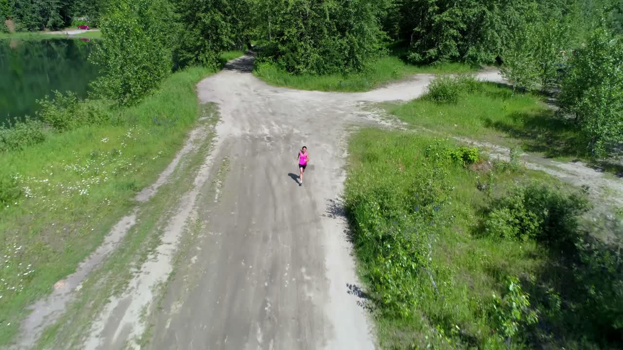 corredora corriendo en el camino del bosque 4k