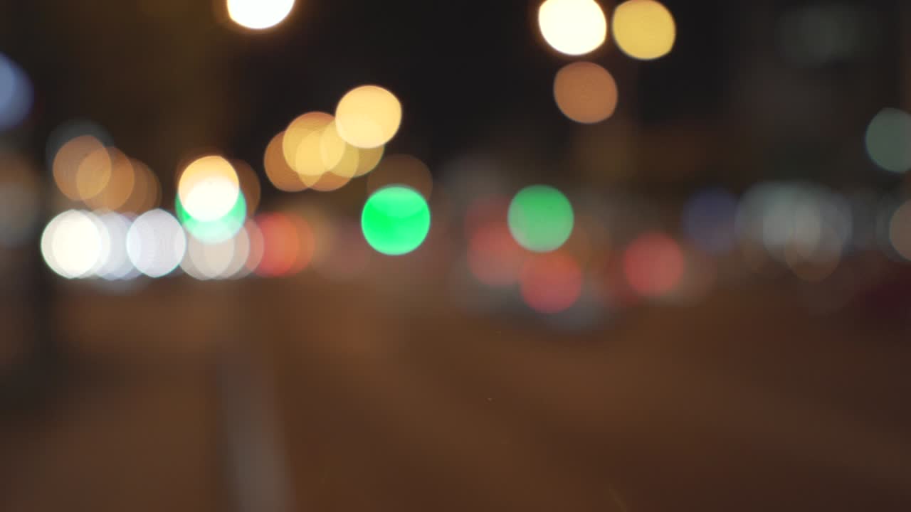 semáforos borrosos ubicados a lo largo de la calle nocturna