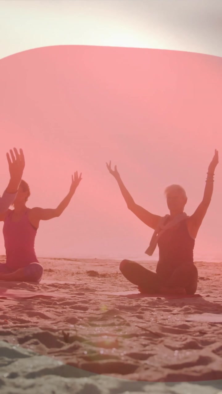 Composite video of waving japan flag against diverse group of people practicing yoga at the beach