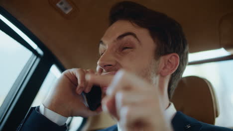 Angry-businessman-making-reprimand-subordinate-on-smartphone-in-automobile.