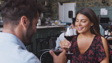 pareja en la primera cita del día de san valentín haciendo un brindis en un restaurante