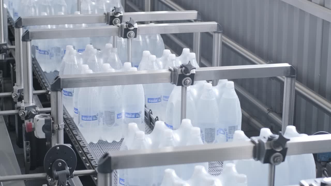 máquina moderna de ataduras y transporte para la línea de envasado en la planta de bebidas