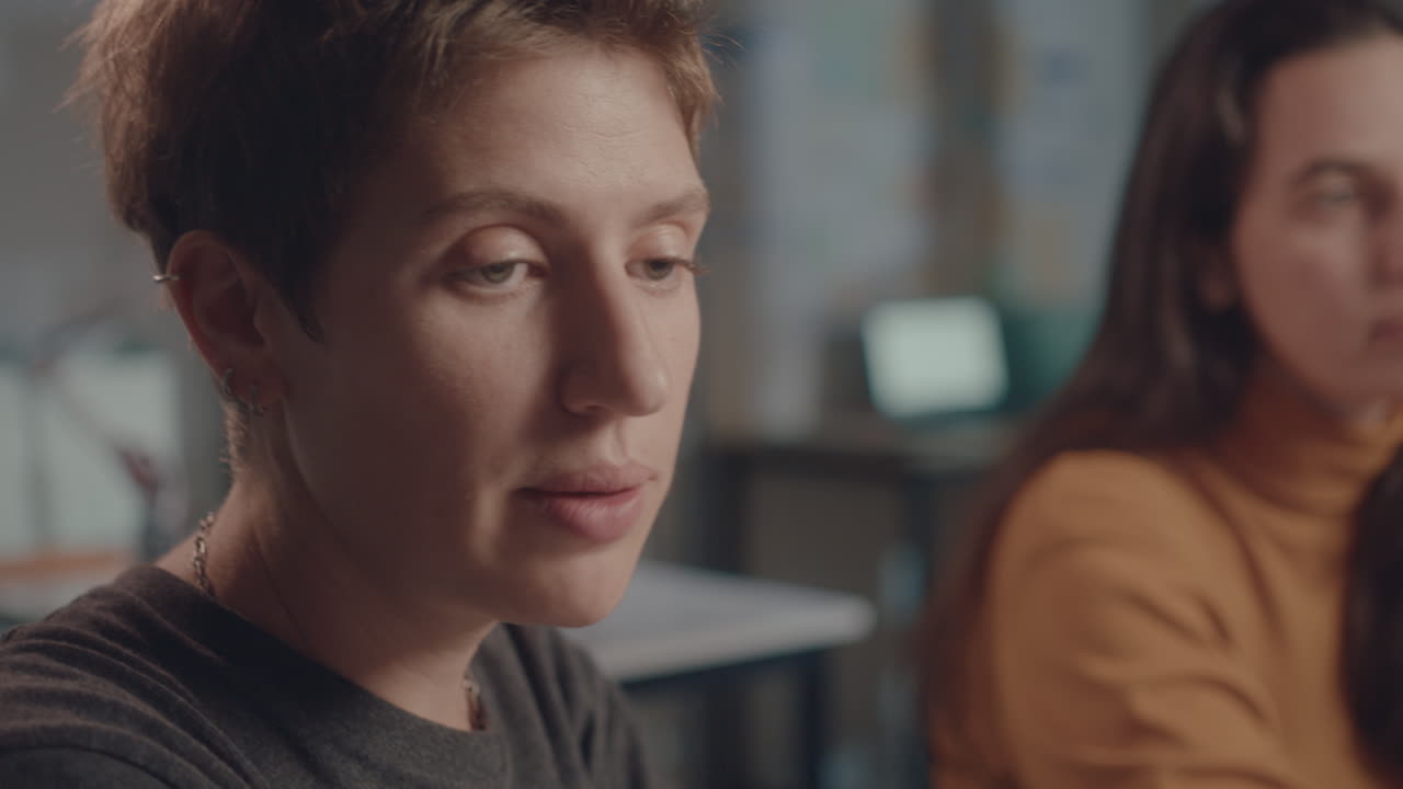Two Young Businesswomen Speaking during Night Office Meeting