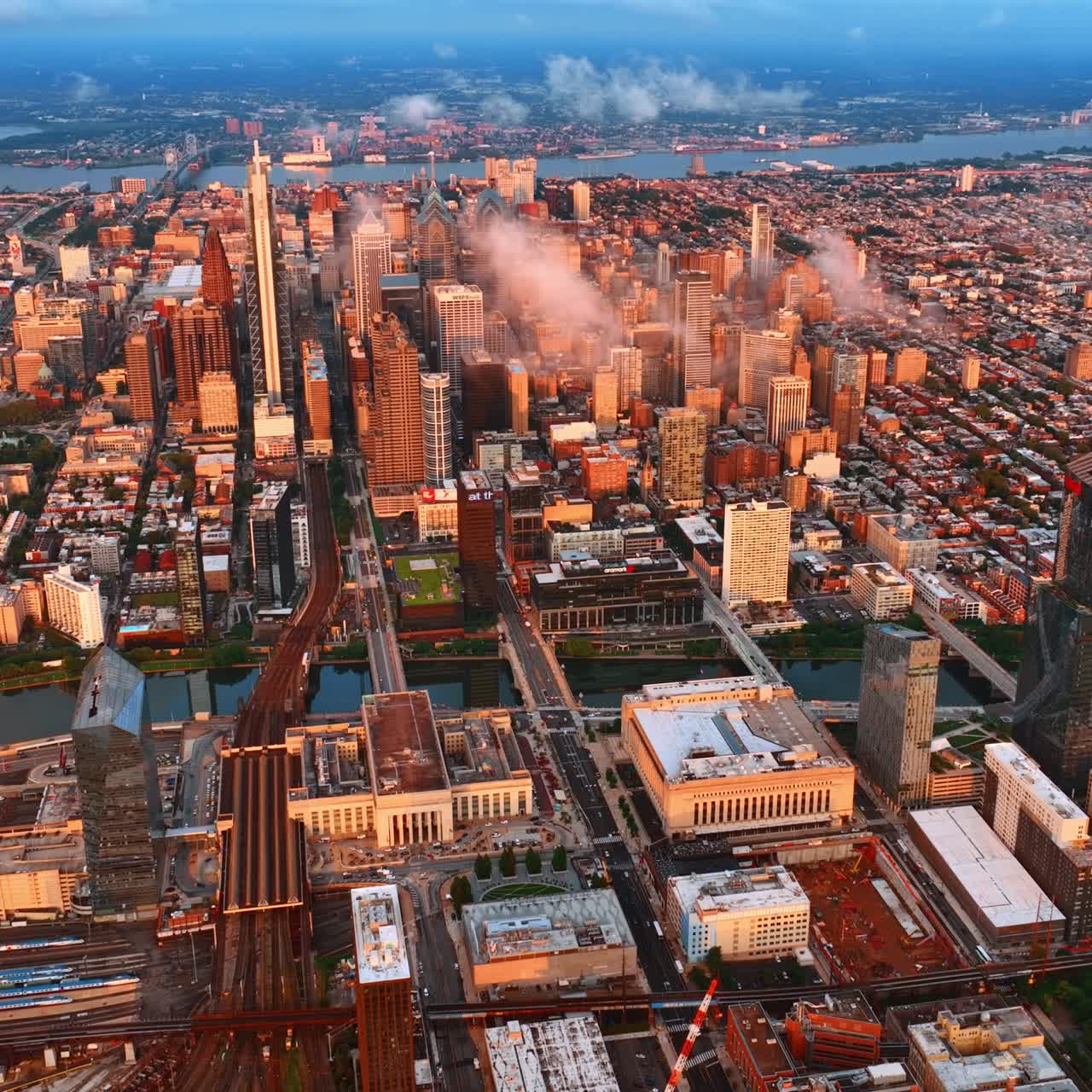 Rays of setting sun lighting the scenery of Philadelphia. Aerial view on the cityscape divided by two rivers
