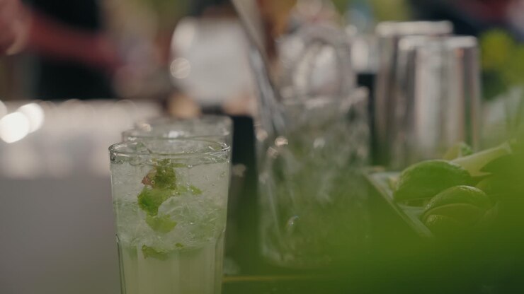 Cocktail con menta e lime preparato al bar in una calda atmosfera all'aperto