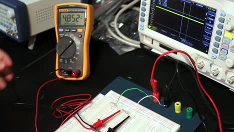 estudiante electricista comprobando voltaje y amperios con multímetro