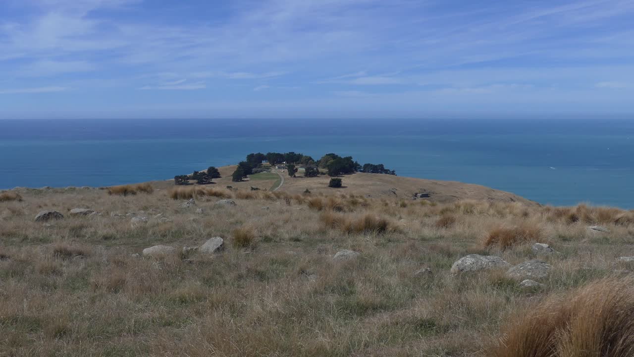 los edificios y los árboles son visibles donde la tierra termina sobre un hermoso océano azul - cabeza de godley, península de los bancos