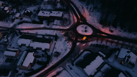 LKW-Fährt-Am-Kreisverkehr-Im-Ländlichen-Winter-Finnlands-Vorbei,-Luftschwenk