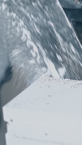 professional worker in gloves finishes sawing big white gypsum plasterboard and takes cut part close view