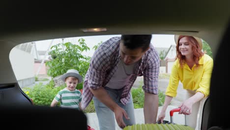 family trip, a young happy couple with their beloved male child luggage in the trunk for a trip while traveling by car during summer vacation