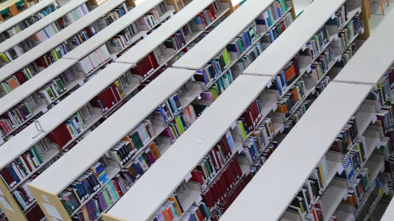 Top down panning shot of rows of book shelves in a library