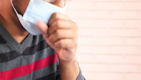 man wearing a face mask and coughing