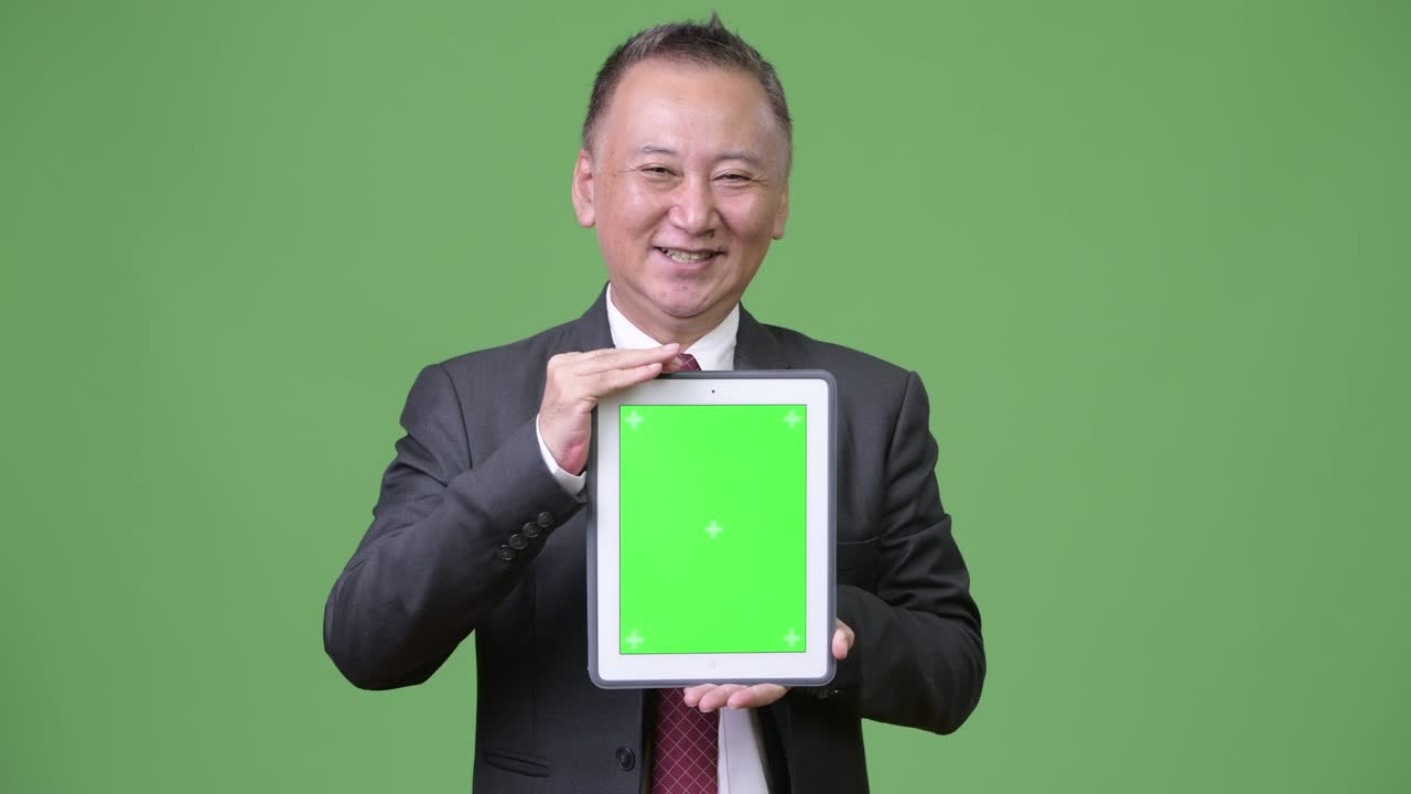 디지털 태블릿을 보여주는 성숙한 일본 사업가
