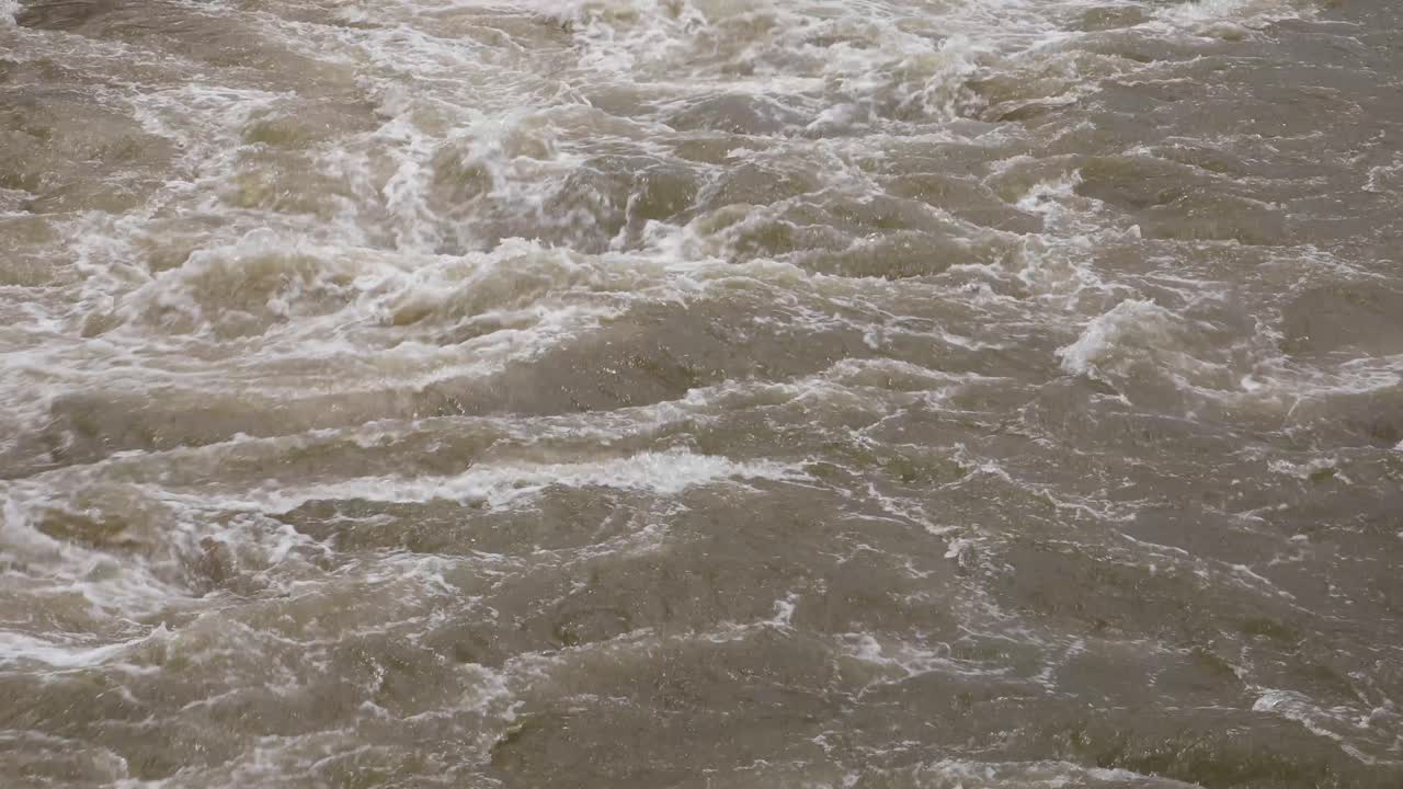 4K Close Up of Murky Water Raging with White Water from a Reservior