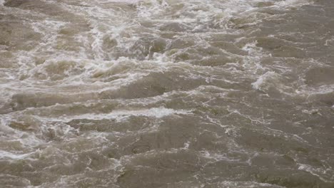 4K Close Up of Murky Water Raging with White Water from a Reservior