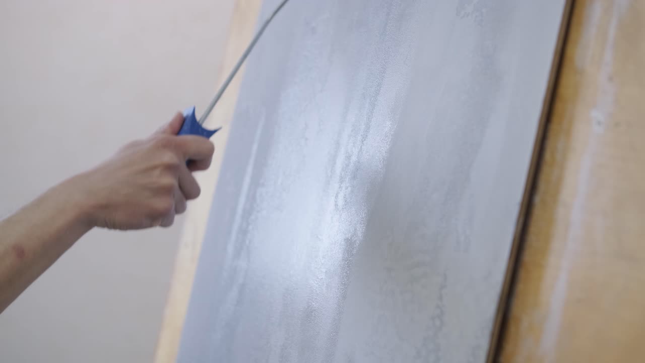 롤러 를 사용 하여 벽 에 페인트 를 붙이는 것