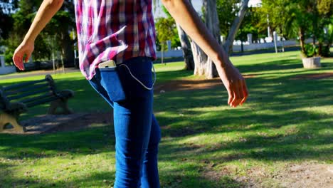 Woman-listening-music-while-playing-in-the-park-4k