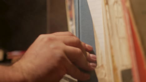 close up of a hand taking a book from a bookshelf and placing it back to its place, while white smoke comes and goes during the action