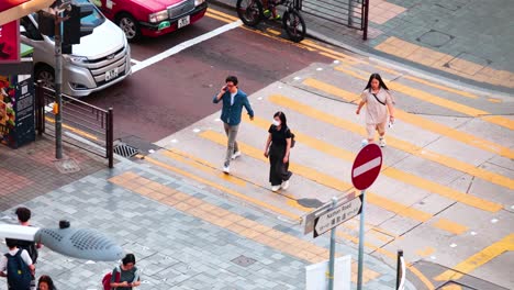 people crossing street at a busy intersection