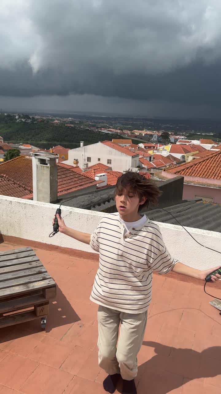 Boy Jumping Rope on Rooftop with City View