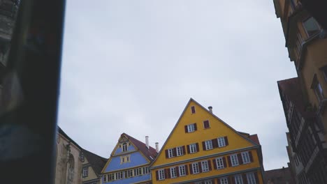 historic town of tubingen germany | woman on phone walking near colorful buildings