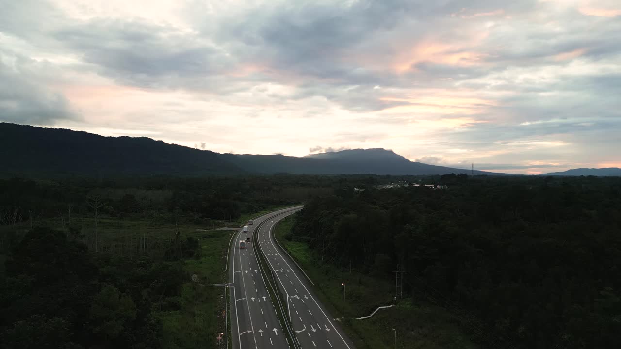 보르네오 고속도로에서 해가 지는 드론 뷰 저녁 녹색 숲과 산, 사라와크.