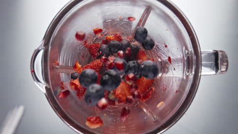 strawberry blueberry falling blender bowl in super slow motion close up.