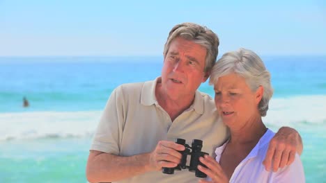 Mature-couple-using-binoculars-