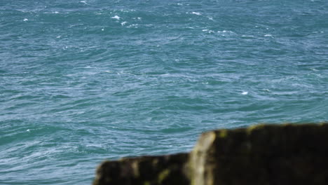 Windy-ocean-in-slow-motion-with-rocks-in-foreground