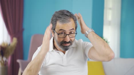 Middle-aged-man-straightening-his-hair.-He-is-looking-at-himself-in-the-mirror.