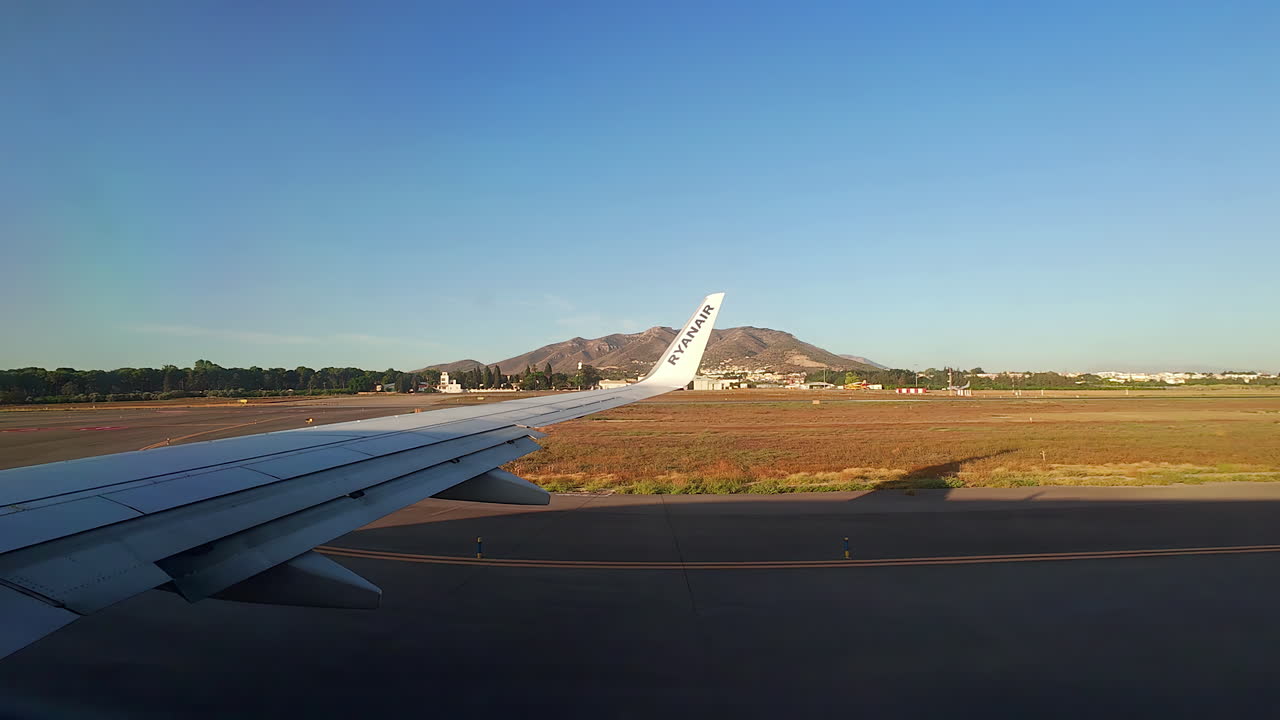 un avión en movimiento disparado desde la ventana y un paisaje abierto con una montaña de españa