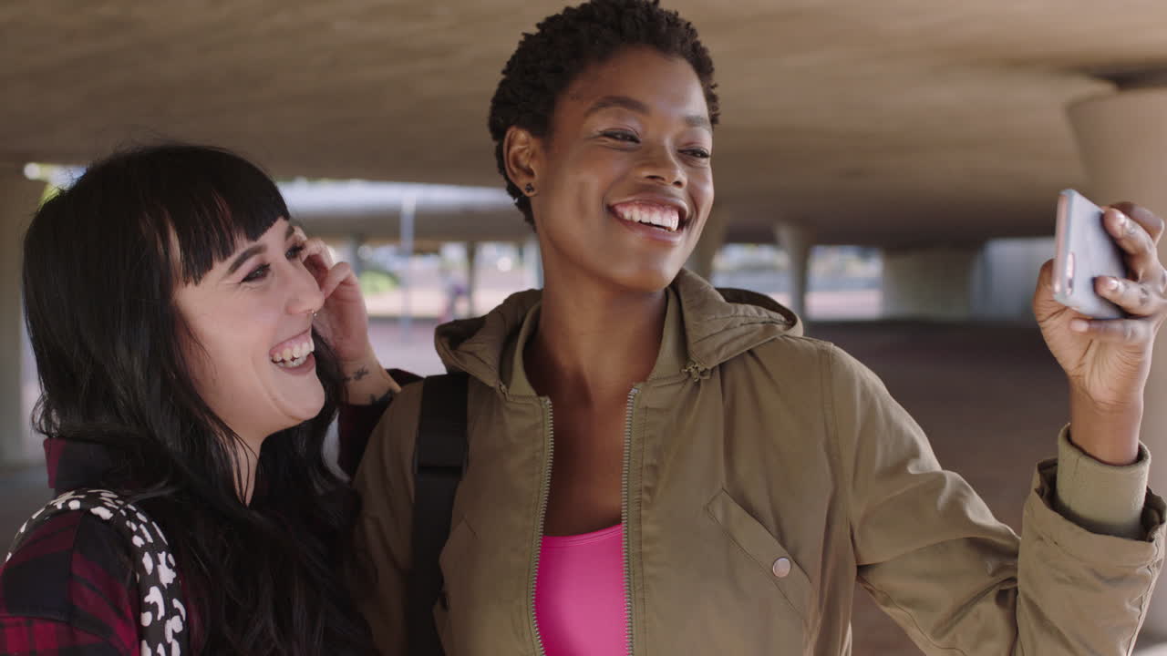 novias alegres usando teléfonos inteligentes sonriendo felices posando para una foto selfie