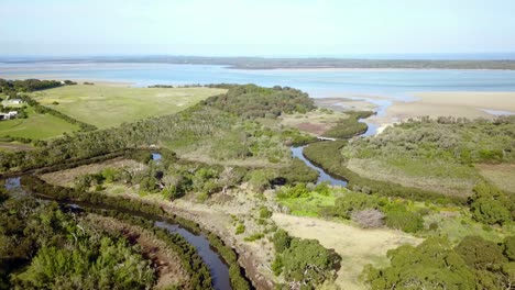 Aerial-footage-over-Screw-Creek-as-it-enters-the-sea-near-Inverloch,-Victoria,-Australia