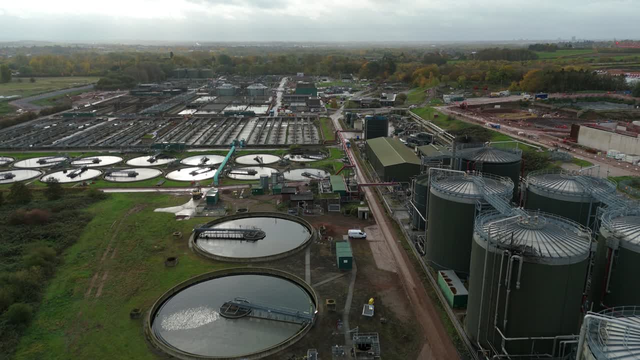 High detail aerial drone video of sewage treatment infrastructure with settling pools, tanks, silos and circular clarifiers in Leicester UK