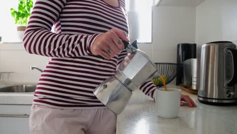 woman preparing coffee in kitchen at home 4k