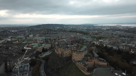 impressive drone shot high above edinburgh castle, slowly moving towards it from arthur's seat and finishing looking down into the castle courtyard