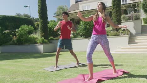 Pareja-Birracial-Enfocada-Practicando-Yoga-Y-Haciendo-Poses-En-El-Jardín-En-Un-Día-Soleado