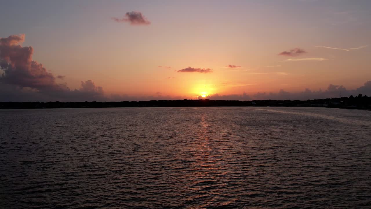 Push shot over Florida Lake med solnedgang bag horisonten, omgivet af skyer