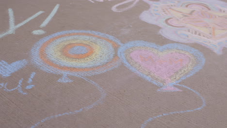 camera drifts over sidewalk chalk art with i heart you and sorry