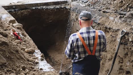 worker taking pictures of rusty pipes in the trench ground overhead view