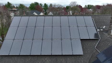 modern solar panels on roof of old house with chimney