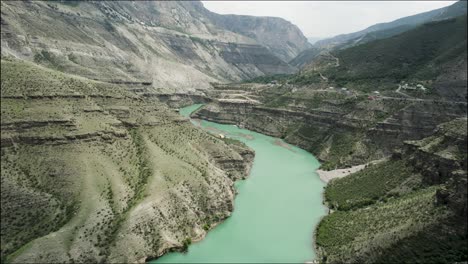 aerial view of a turquoise river winding through a mountain valley