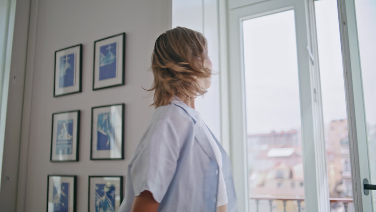 Ragazza felice si rilassa a casa la mattina nel suo nuovo appartamento accogliente. Donna allegra che ride