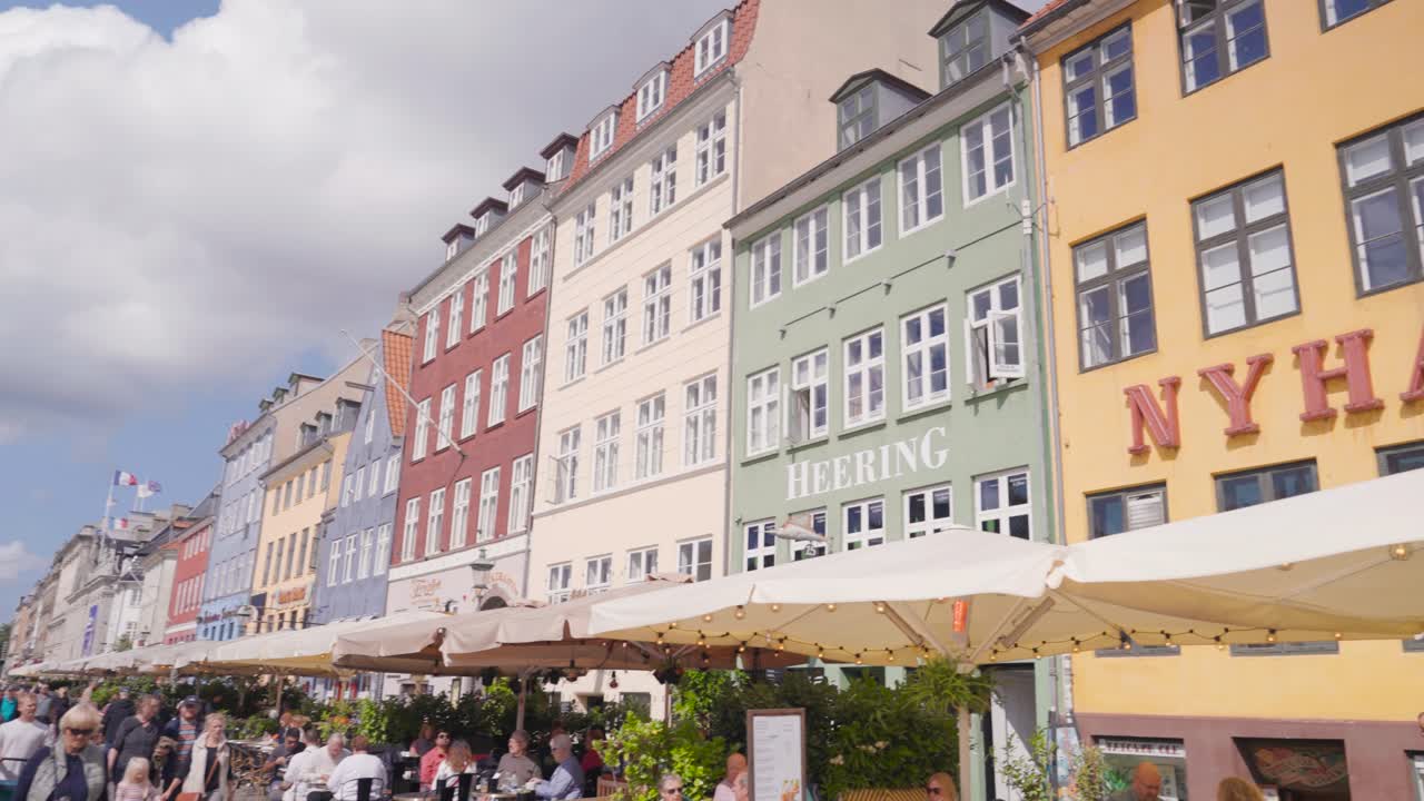 People near Nyhavn waterfront buildings, entertainment district in Copenhagen