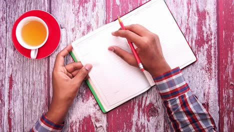 persona de planificación con un cuaderno y té