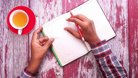 person planning with a notebook and tea