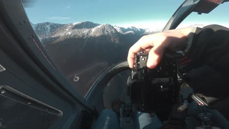 pov of a guy taking photos in the cockpit of a flying helicopter in canada, bc