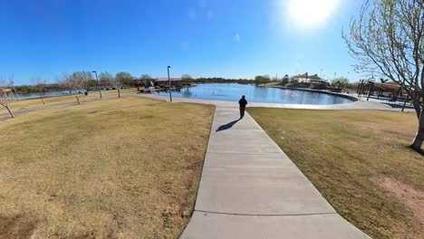 static red haired male walking by a lake in mansel crater park in queen creek arizona.